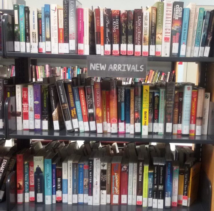Full book shelves labeled with "New Arrivals"